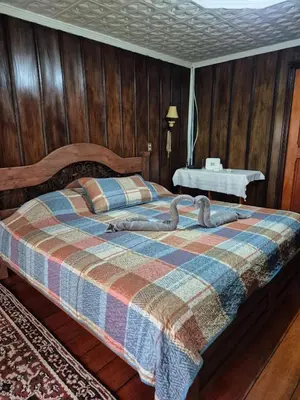 a bed in a bedroom with wooden walls at Villa Azul in Abundancia