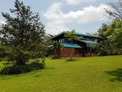a house with a green lawn in front of it at Villa Azul in Abundancia