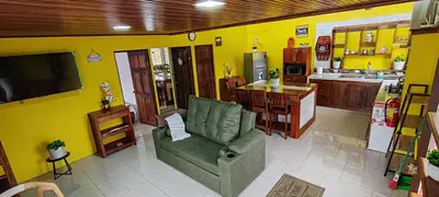 a living room with a green couch and a kitchen at Monteverde Coati & Sloth Studios Apartaments Hotel in Monteverde Costa Rica