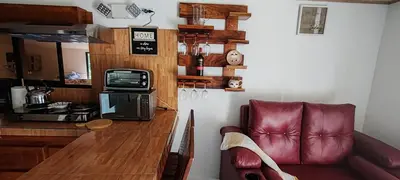 a living room with a couch and a counter with a microwave at Monteverde Coati & Sloth Studios Apartaments Hotel in Monteverde Costa Rica