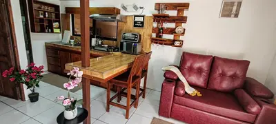 a living room with a red couch and a kitchen at Monteverde Coati & Sloth Studios Apartaments Hotel in Monteverde Costa Rica