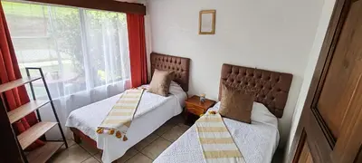 two beds in a small room with a window at Monteverde Coati & Sloth Studios Apartaments Hotel in Monteverde Costa Rica
