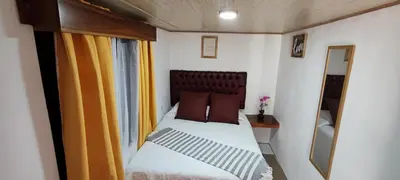 a small bed in a small room with a window at Monteverde Coati & Sloth Studios Apartaments Hotel in Monteverde Costa Rica