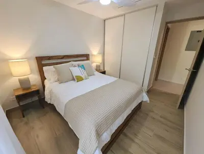 a bedroom with a large white bed and two lamps at Stylish 2 bed and 2 bath condo with mountain and pool view in Jacó in Jacó