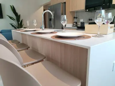 a kitchen with a counter with wine glasses on it at Stylish 2 bed and 2 bath condo with mountain and pool view in Jacó in Jacó
