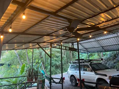 a white truck parked under a metal roof at The Emerald Haven in Parrita