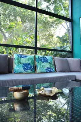 a couch sitting in front of a large window at The Emerald Haven in Parrita