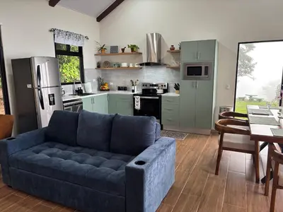 a living room with a blue couch in a kitchen at Apricus Costa Rica in Monteverde Costa Rica