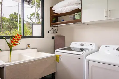 a small kitchen with a washing machine and a sink at Apricus Costa Rica in Monteverde Costa Rica