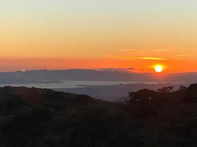 a sunset with the sun setting over the ocean at Apricus Costa Rica in Monteverde Costa Rica