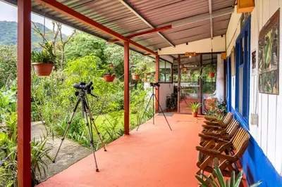 a camera on a tripod next to a building with a cameraman at Monteverde Wildlife Paradise - Nature Lovers in San Luis