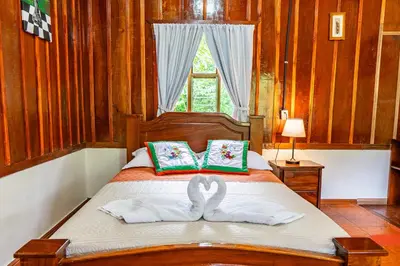 a bedroom with a bed with towels and a window at Monteverde Wildlife Paradise - Nature Lovers in San Luis