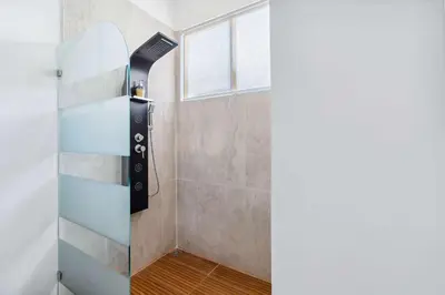 a shower with a glass door in a bathroom at Waterfall Pool, Kids' Paradise, Quiet Beaches in Playa Grande