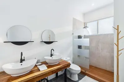a bathroom with two sinks and a toilet at Waterfall Pool, Kids' Paradise, Quiet Beaches in Playa Grande
