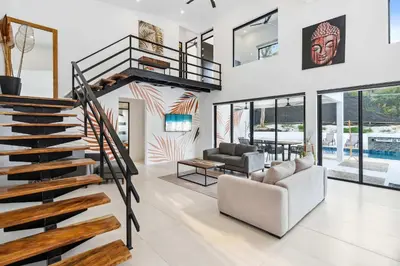 a living room with a spiral staircase and a couch at Waterfall Pool, Kids' Paradise, Quiet Beaches in Playa Grande