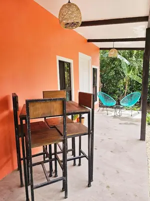 a wooden table and chairs on a patio at Cara Coral, un oasis en la Selva in Tortuguero