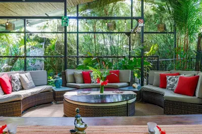 a screened in porch with couches and a table at Danyasa Eco-Retreat in Dominical