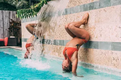 two women in bathing suits playing in a fountain at Danyasa Eco-Retreat in Dominical