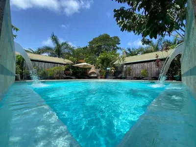a swimming pool with water fountains in a yard at Danyasa Eco-Retreat in Dominical