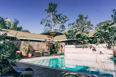 a swimming pool next to a fence with trees at Danyasa Eco-Retreat in Dominical