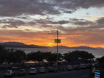 a parking lot with cars parked in front of a sunset at Todo incluido en Yate a Isla Tortuga con habitacion de hotel en Puntarenas in Puntarenas