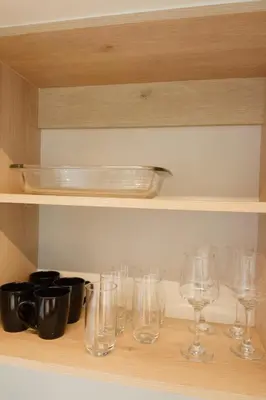 a row of wine glasses sitting on a shelf at Luxury Suite Torres Del Mar Jacó in Jacó