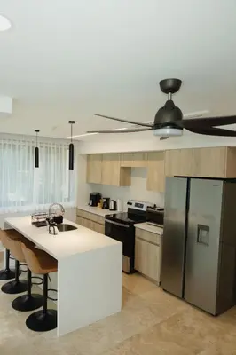 a kitchen with a white counter and a refrigerator at Luxury Suite Torres Del Mar Jacó in Jacó
