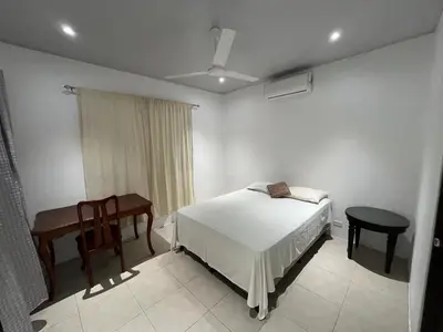 a bedroom with a bed and a table and a chair at Casa playa 2 in Huacas