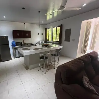 a kitchen with a counter and a couch in a room at Casa playa 2 in Huacas