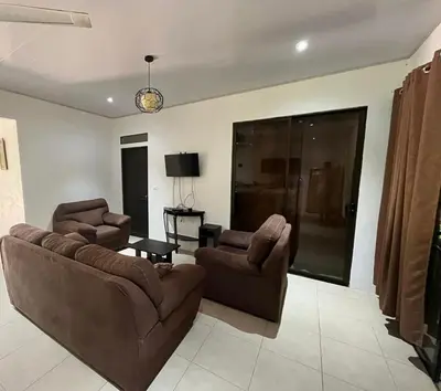 a living room with a couch and two chairs and a table at Casa playa 2 in Huacas
