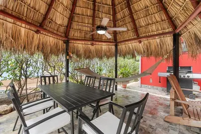 a patio with a table and chairs and a hammock at VBM6 Delightful Beachside Cottage Close to Beach in Tamarindo