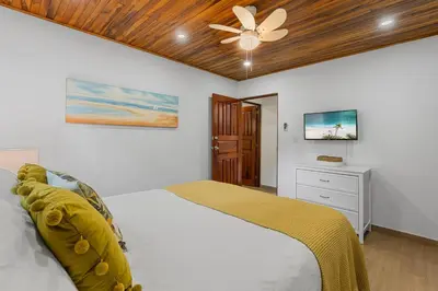 a bedroom with a bed and a ceiling fan at VBM6 Delightful Beachside Cottage Close to Beach in Tamarindo