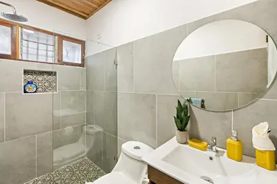 a bathroom with a sink and a shower and a mirror at VBM6 Delightful Beachside Cottage Close to Beach in Tamarindo