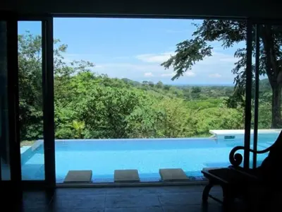 a view of a swimming pool through a window at Casa Candelitas Private Yoga ocean view house in Nicoya