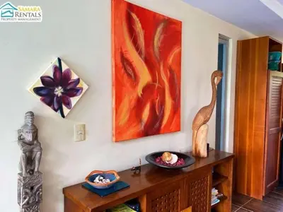 a room with a table with a painting on the wall at Casa Candelitas Private Yoga ocean view house in Nicoya