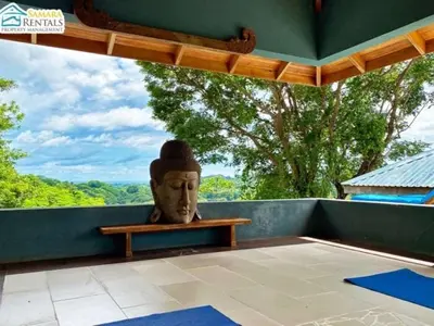 a statue of a head sitting on a porch at Casa Candelitas Private Yoga ocean view house in Nicoya