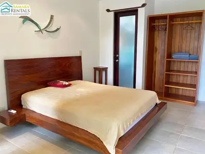 a bedroom with a large bed with a wooden headboard at Casa Candelitas Private Yoga ocean view house in Nicoya