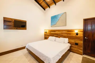 a bedroom with a bed and a flat screen tv at Casa Caoba Playa Potrero in Playa Flamingo