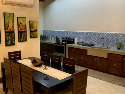 a kitchen with a table and a sink and a stove at Casa Caoba Playa Potrero in Playa Flamingo