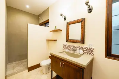a bathroom with a sink and a toilet and a mirror at Casa Caoba Playa Potrero in Playa Flamingo