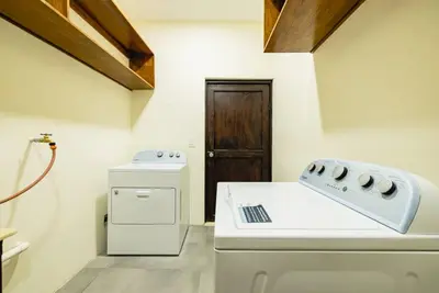 a kitchen with a stove and a washer and dryer at Casa Caoba Playa Potrero in Playa Flamingo