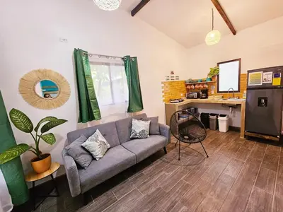 a living room with a couch and a desk at Casa Selvamar, un oasis en la selva in Tortuguero