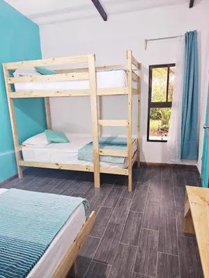 a room with two bunk beds and a table at Casa Selvamar, un oasis en la selva in Tortuguero