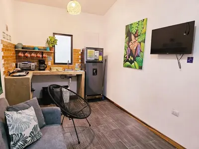 a living room with a couch and a desk with a computer at Casa Selvamar, un oasis en la selva in Tortuguero
