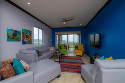 a living room with blue walls and couches at AltaVista 4C 3 bdr Ocean View in Los Suenos in Herradura
