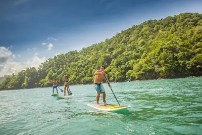 three people on paddle boards in the water at AltaVista 4C 3 bdr Ocean View in Los Suenos in Herradura