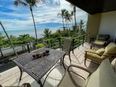 a table and chairs on a balcony with a view of the ocean at Beachfront Exotic Family Groups Retreat Wedding in Jacó