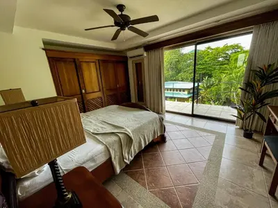 a bedroom with a bed and a ceiling fan at Beachfront Exotic Family Groups Retreat Wedding in Jacó