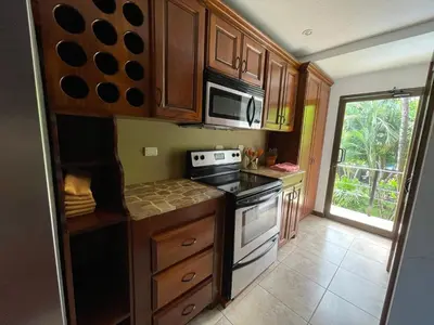 a kitchen with a stove and a microwave at Beachfront Exotic Family Groups Retreat Wedding in Jacó