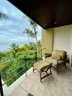 a balcony with a chair and a table at Beachfront Exotic Family Groups Retreat Wedding in Jacó
